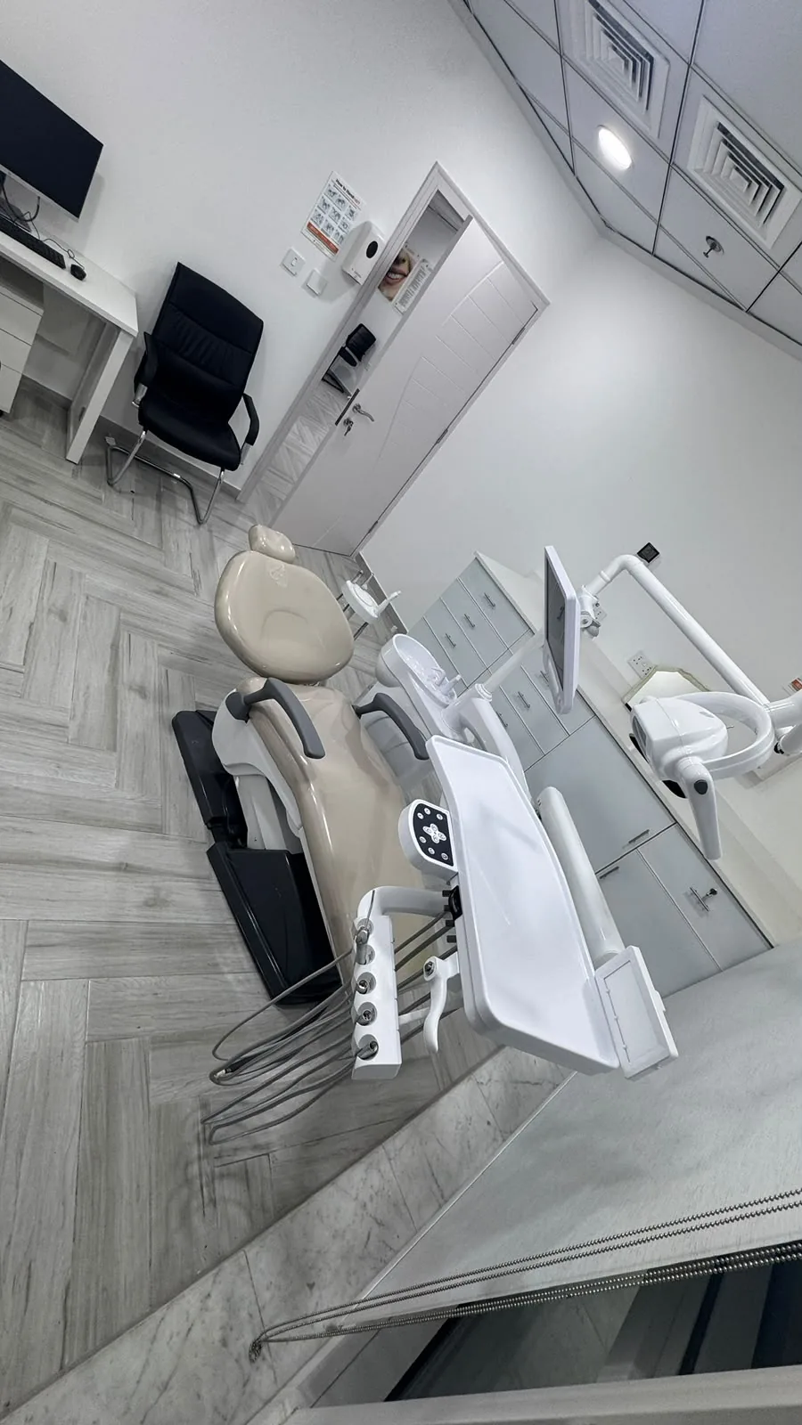 Treatment room at KERVA Dental Clinic with dental chair, delivery unit and operating light